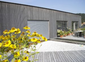 Elegante Holzfassade in Silbergrau, Terrassenboden in Holz